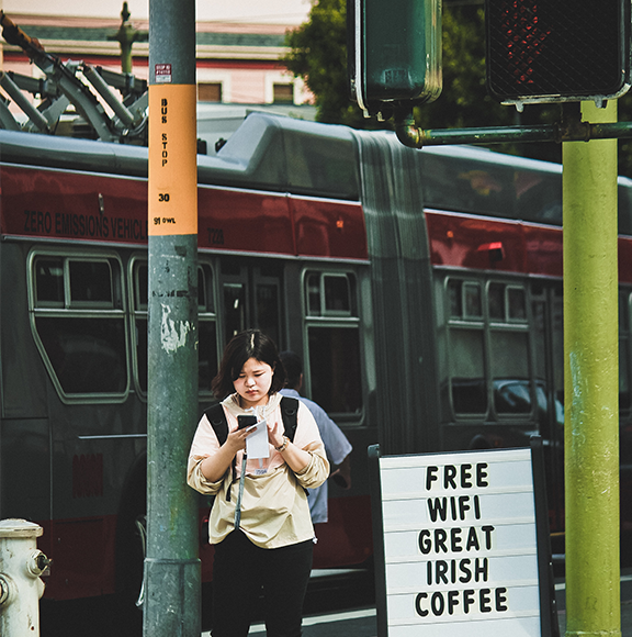 Girl with smartphone and advertising for free WiFi and great Irish coffee